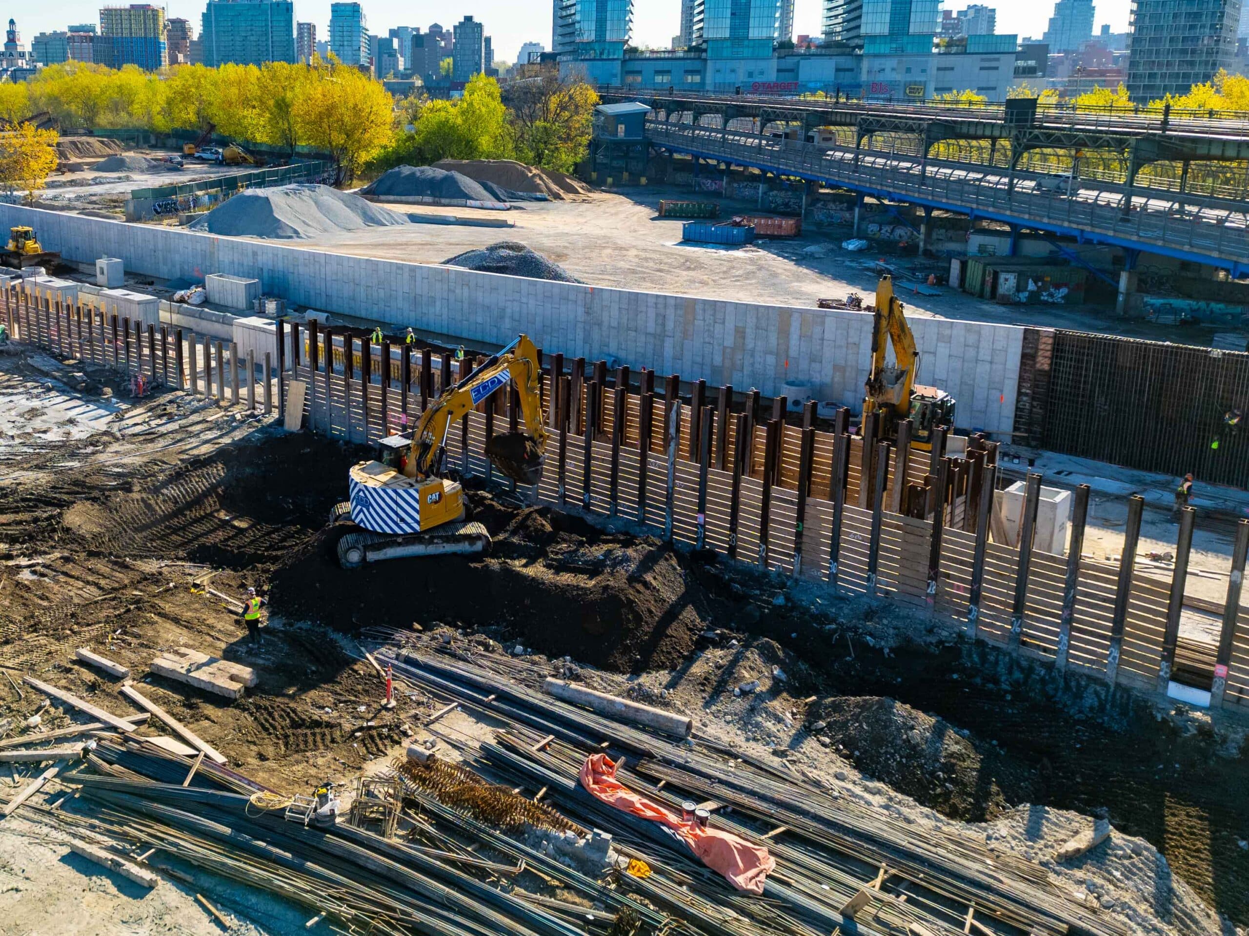 ECD installing soldier piles and timber lagging for support of excavation